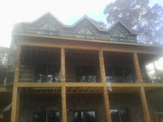 Dormers and porch framing on a large log home under construction — Roof Coating work by our crew in Indian Valley